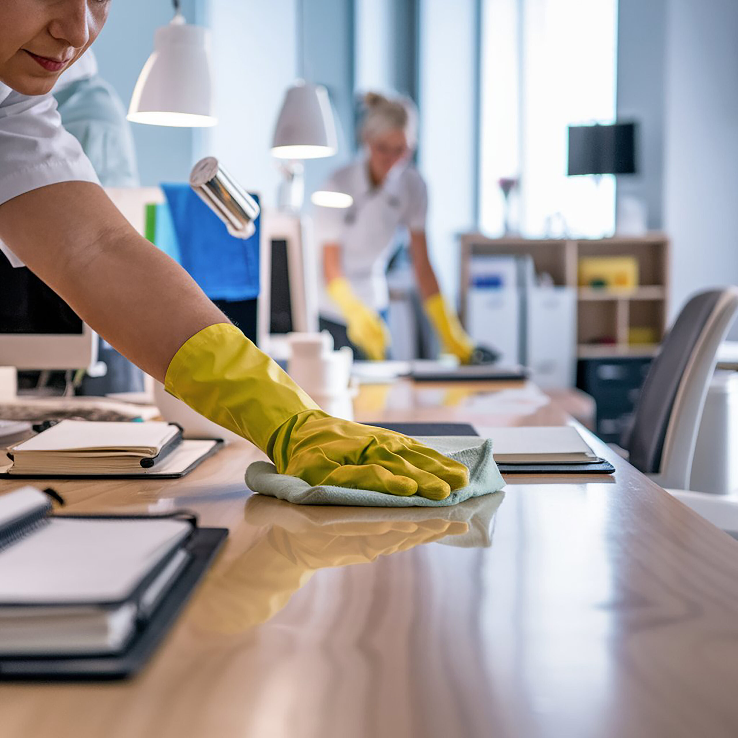 cleaning team member wiping office desk