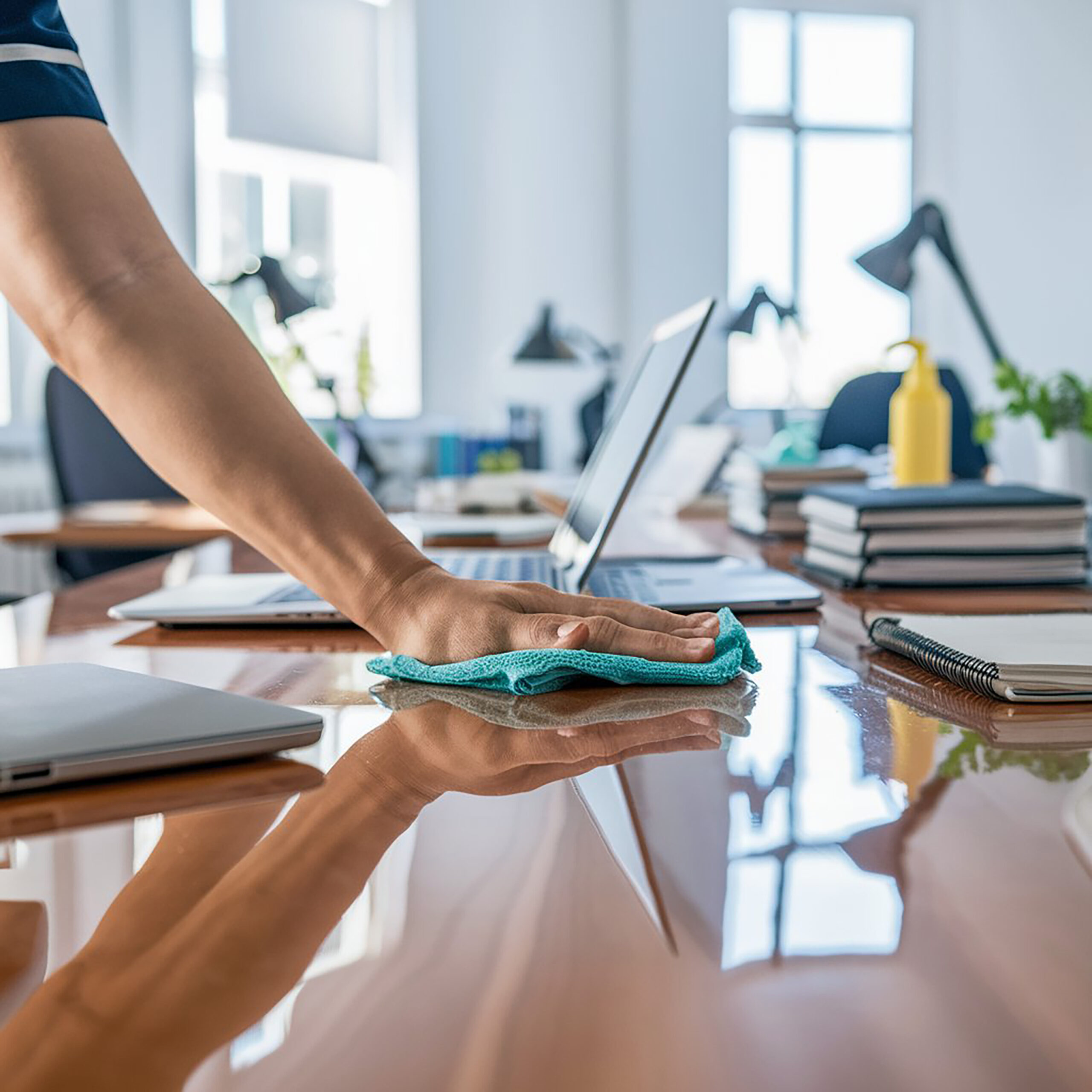cleaning team member wiping office desk